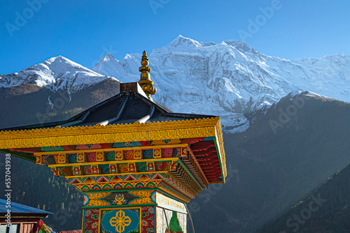 Colorful temple enterence way by the Annapurna mountain range in the distance, Nepal. Shot on a sunny fall day