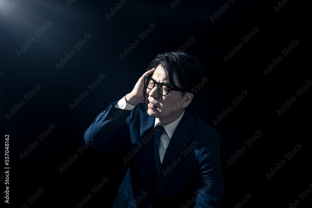 頭を抱えて苦しんでいるスーツを着たビジネスマンの男性
頭を抱えて苦しんでいるスーツを着たビジネスマンの男性