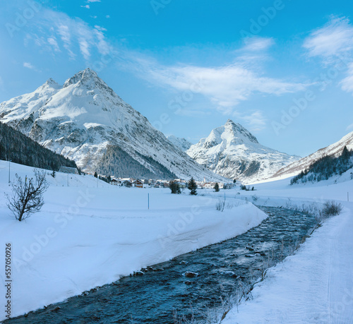 Winter mountain stream view and village in valley (Austria).