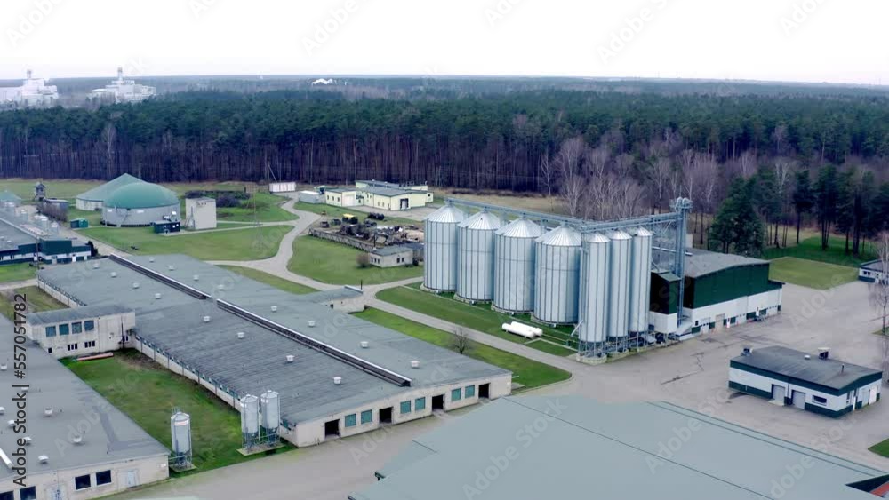 Aerial view of pig farm with grain drying towers and biogas plant. Modern complex for drying, cleaning and storage a grain. High quality 4k ProRes footage