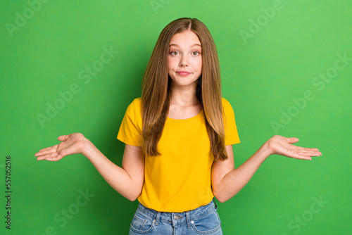 Photo of cute indifferent grimace schoolgirl teenager wear orange t-shirt hold palm dont know where stolen money isolated on green color background
