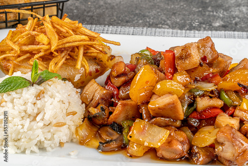  Chicken sauteed with vegetables served with rice, potatoes and bread photo