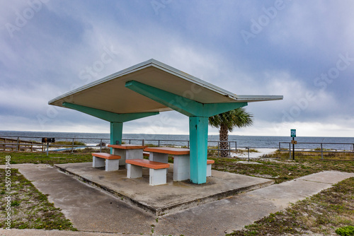 A mid-century modern style concrete picnic shelter and tables on a beach in Florida.
