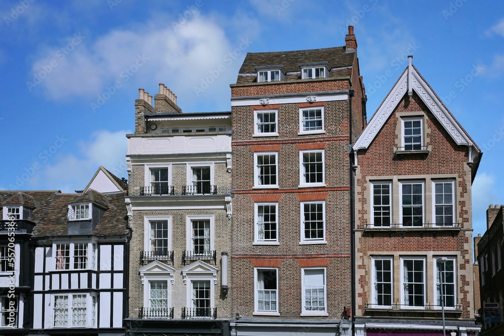 Row of tall, narrow old buildings with apartments on top and stores below, Cambridge, England