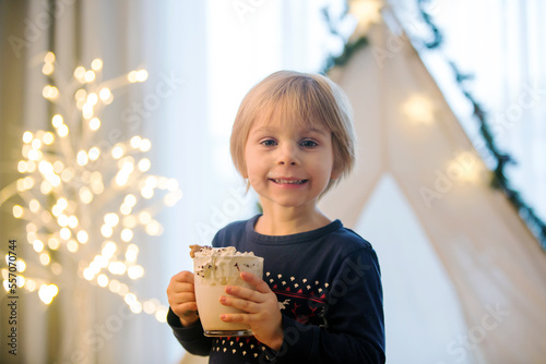 Beautiful blond toddler child  boy  drinking hot cocoa with wipped cream