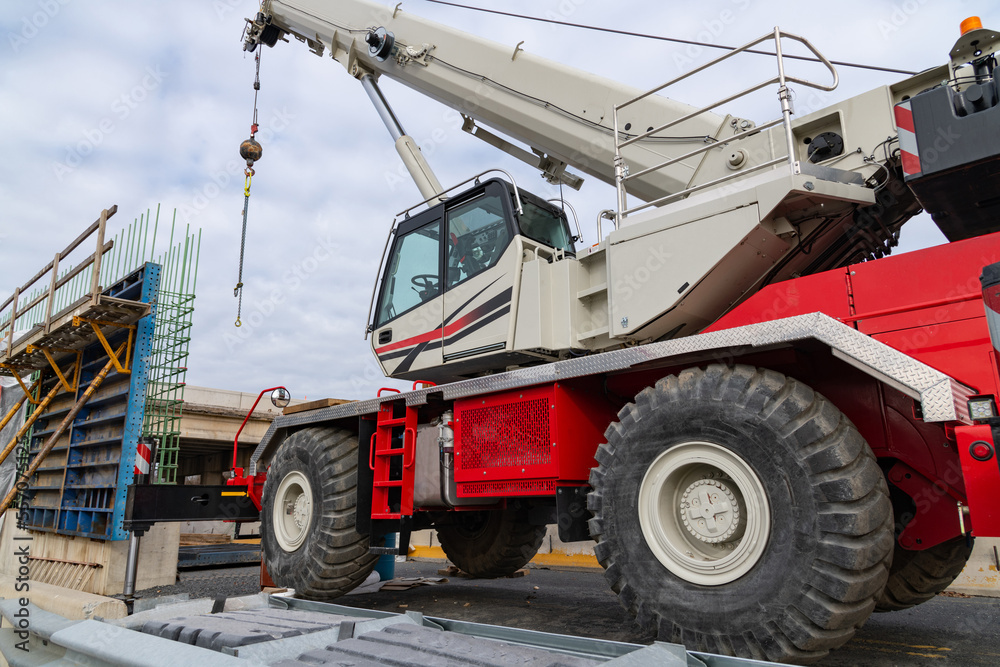 Truck crane with a raised boom with a hook on the construction site of a road bridge Truck crane with a raised boom with a hook on the construction site of a road bridge