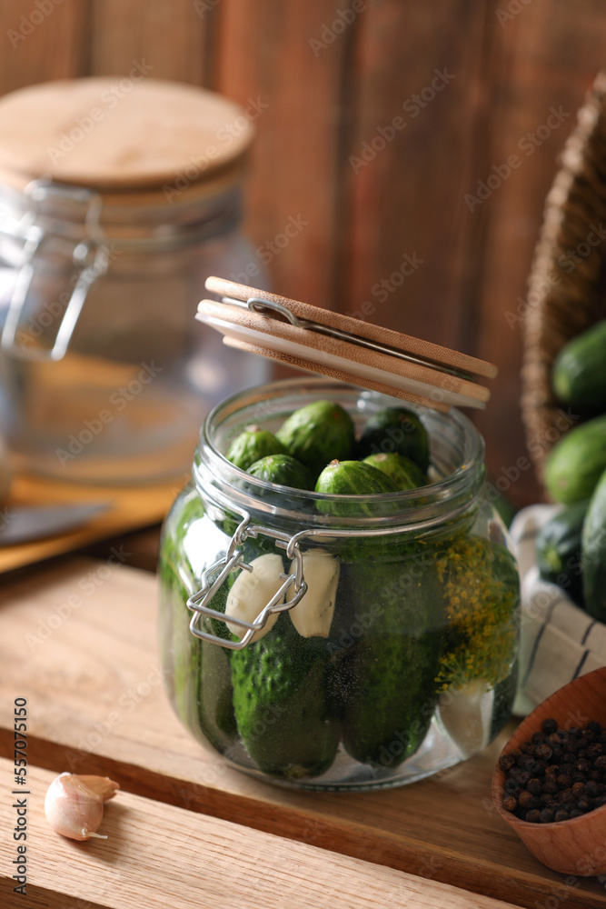 Glass jar with fresh cucumbers and other ingredients on wooden table. Canning vegetable Glass jar with fresh cucumbers and other ingredients on wooden table. Canning vegetable