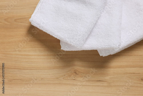 Soft folded terry towels on wooden table, top view. Space for text