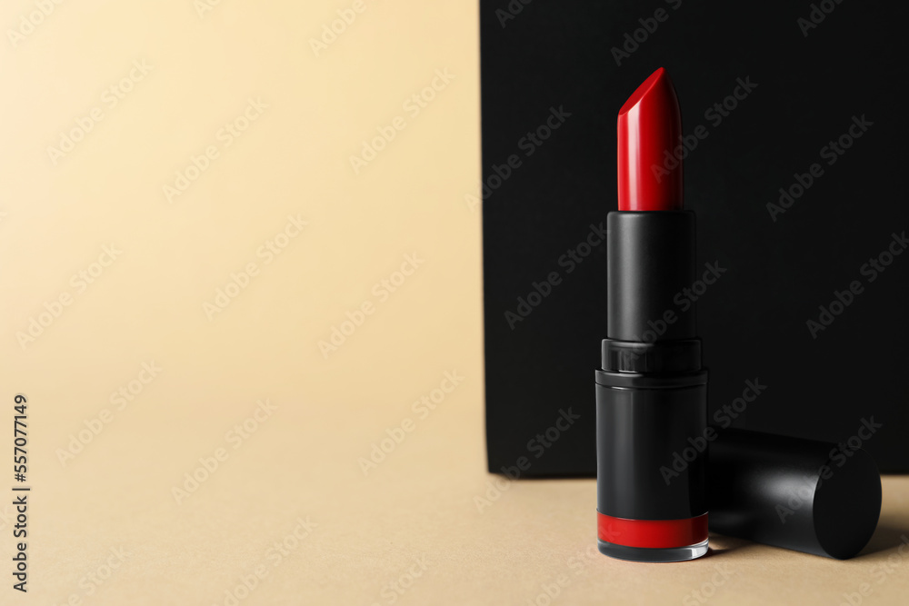 Beautiful glossy red lipstick on beige background, space for text Beautiful glossy red lipstick on beige background, space for text