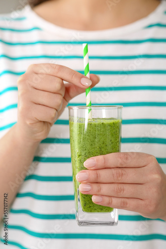 Woman holding glass with delicious smoothie, closeup