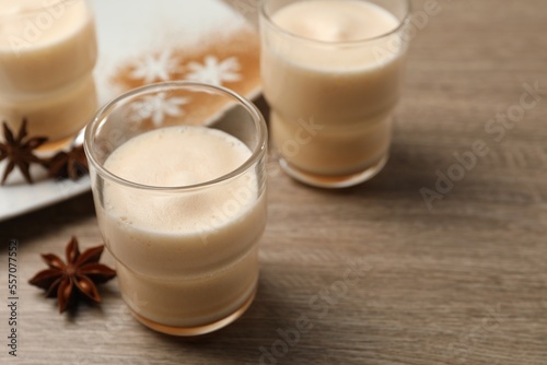 Delicious eggnog with anise on wooden table. Space for text