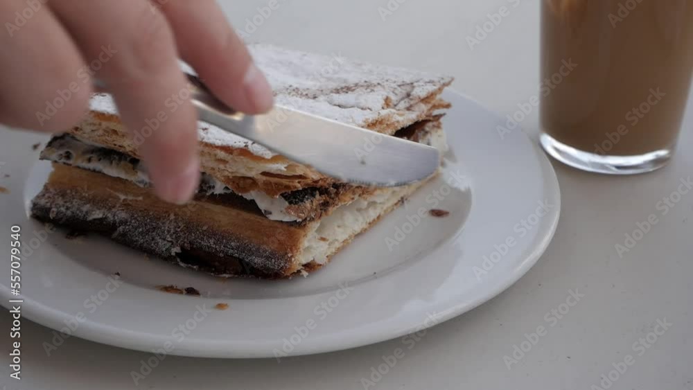 Video „Closeup woman hands cutting piece of millefeuille with knife