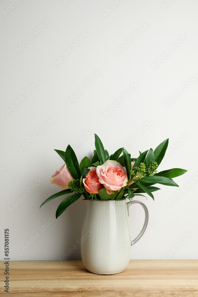 Bouquet of beautiful flowers in vase on wooden table against white background Bouquet of beautiful flowers in vase on wooden table against white background