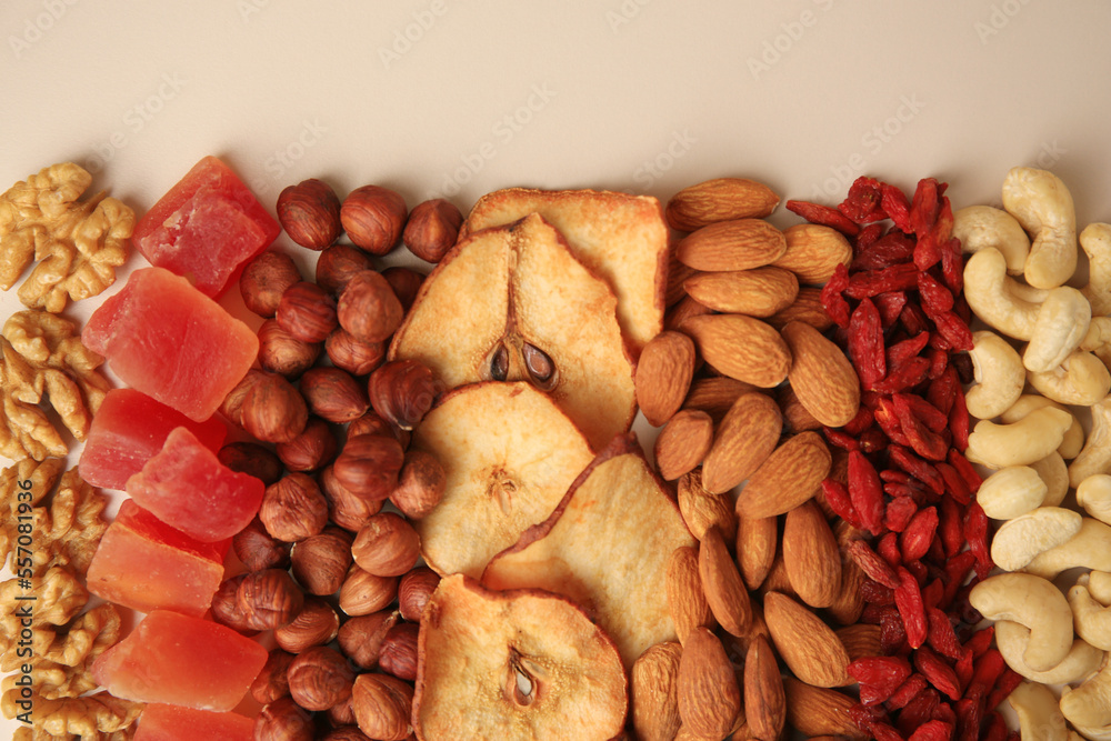 Mix of delicious dried nuts and fruits on beige background, flat lay Mix of delicious dried nuts and fruits on beige background, flat lay