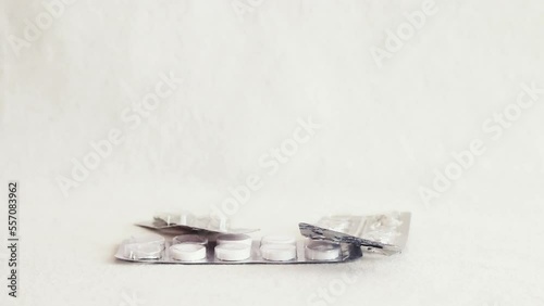 Medicine blister pack falling one by one and piling up on white background