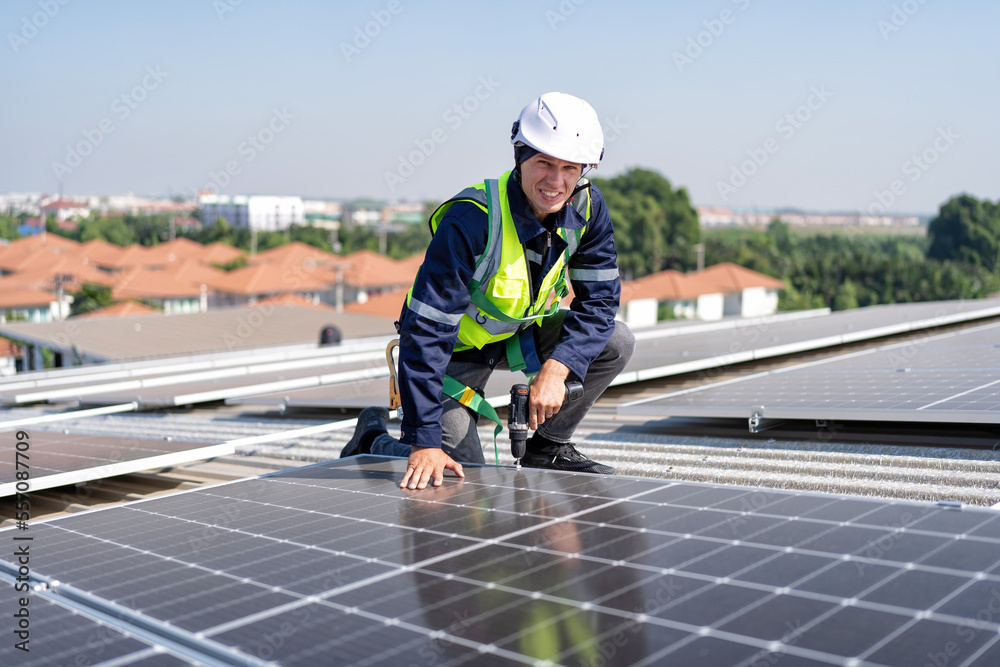 Engineer on rooftop kneeling next to solar panels photo voltaic with tool in hand for installation Engineer on rooftop kneeling next to solar panels photo voltaic with tool in hand for installation