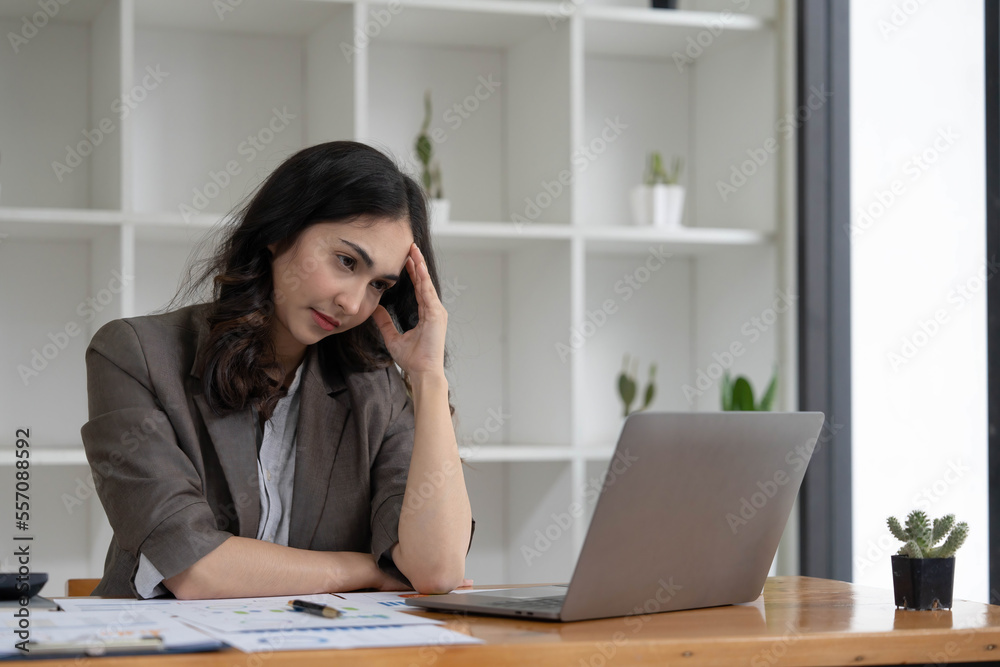 Portrait of serious young businesswoman accountant in formal wear sitting at her work place and use laptop, summarizing taxes, planning future investments, accounting at office. Portrait of serious young businesswoman accountant in formal wear sitting at her work place and use laptop, summarizing taxes, planning future investments, accounting at office.