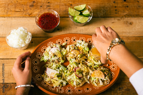 Woman's hands preparing Colima style sopitos on wooden table. Typical Mexican food. photo