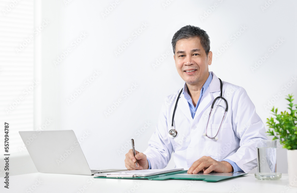 Asain male doctor writing document at office desk. Asain male doctor writing document at office desk.
