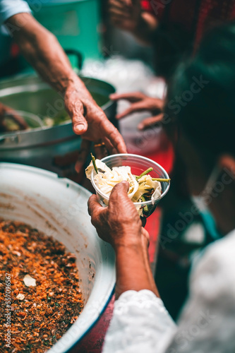 Concept of giving free food to the poor in the community : Volunteers handing out food to hungry people