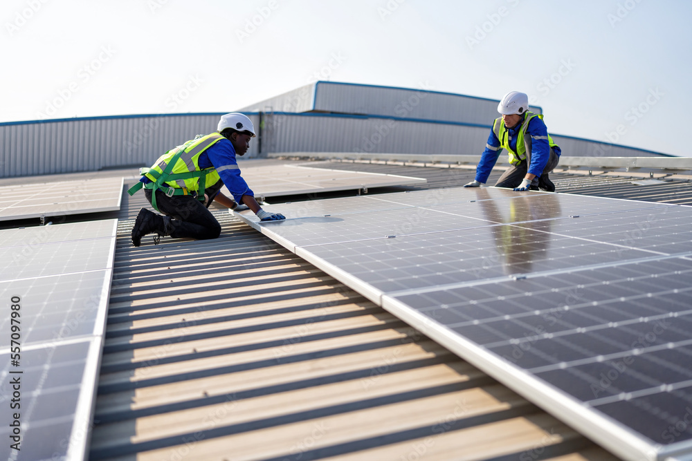 Engineer on rooftop sitting next to solar panels photo voltaic check alignment for good installation Engineer on rooftop sitting next to solar panels photo voltaic check alignment for good installation