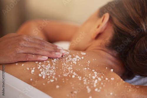 Skincare, spa and woman with salt, luxury and massage back at resort. Female enjoy scrubbing, lady and beauty salon to relax, health and dermatology for exfoliating, skin wellness and natural care.