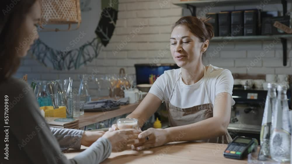 Bar counter in a small coffee shop. A female barista dispenses coffee from a counter. Bar counter in a small coffee shop. A female barista dispenses coffee from a counter.
