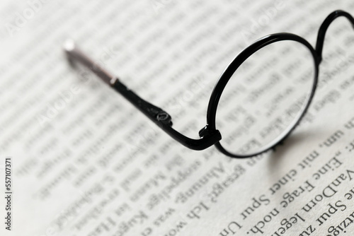 Reading glasses close-up on the pages of a book .Symbol of study  knowledge and reading.Reading concept.