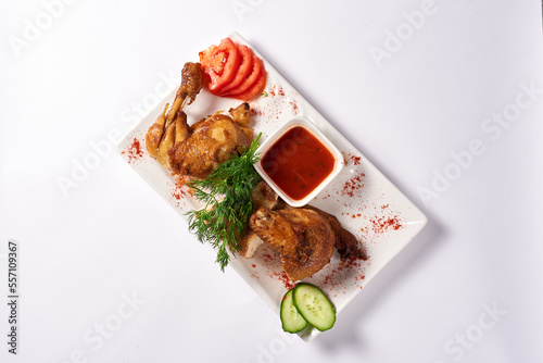 fried chicken with tomato sauce, cucumbers and tomatoes. on a white background