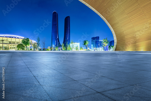 Empty square floor and modern city skyline with buildings at night in Hangzhou, China.