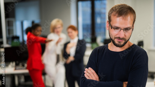 Принти на полотні A middle-aged man is upset because of the ridicule of his female colleagues