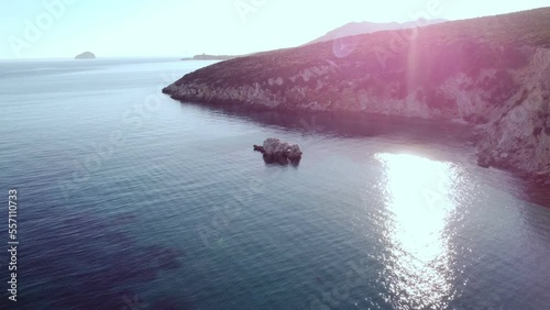 Scenic aerial view of sea rock formation in secluded bay, peaceful water, sunset