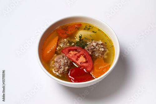 soup with meatballs in a plate on a white background