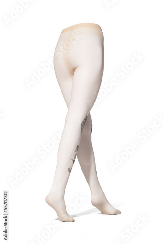 Detailed shot of beige tights with a color print imitating tattoo at the front. The tattoo-effect pantyhose have a shape of walking women's legs. The clothes are isolated on the white background.