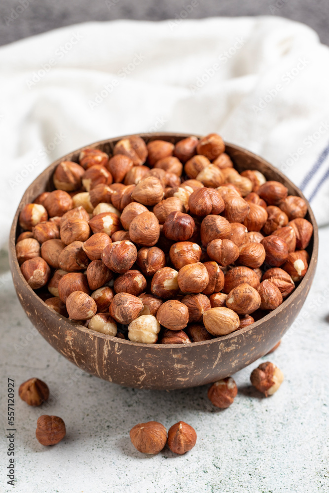 Raw hazelnuts on a gray background. Nuts in a coconut bowl. close up Raw hazelnuts on a gray background. Nuts in a coconut bowl. close up