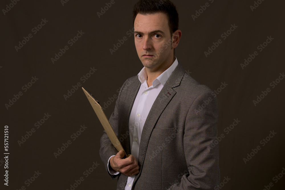interesting mature businessman with clipboard looking at camera worried due to bad results in economic company. High quality photo interesting mature businessman with clipboard looking at camera worried due to bad results in economic company. High quality photo