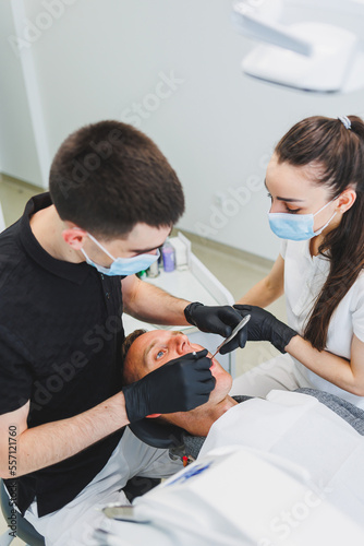 Dental office  examining a patient in a dental chair. Dental treatment is performed by a doctor and an assistant. Dental care.