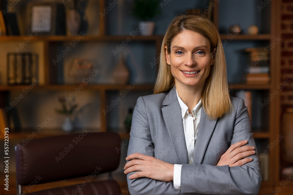 Young businesswoman in suit posing with arms folded, looking at camera and smiling. Female leadership concept Young businesswoman in suit posing with arms folded, looking at camera and smiling. Female leadership concept