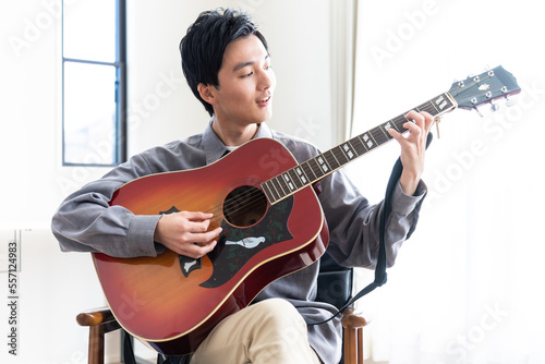 ギターを聞く若い日本人男性 #557124983