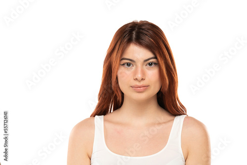 Portrait of serious beautiful woman with long straight ginger hair on a white background