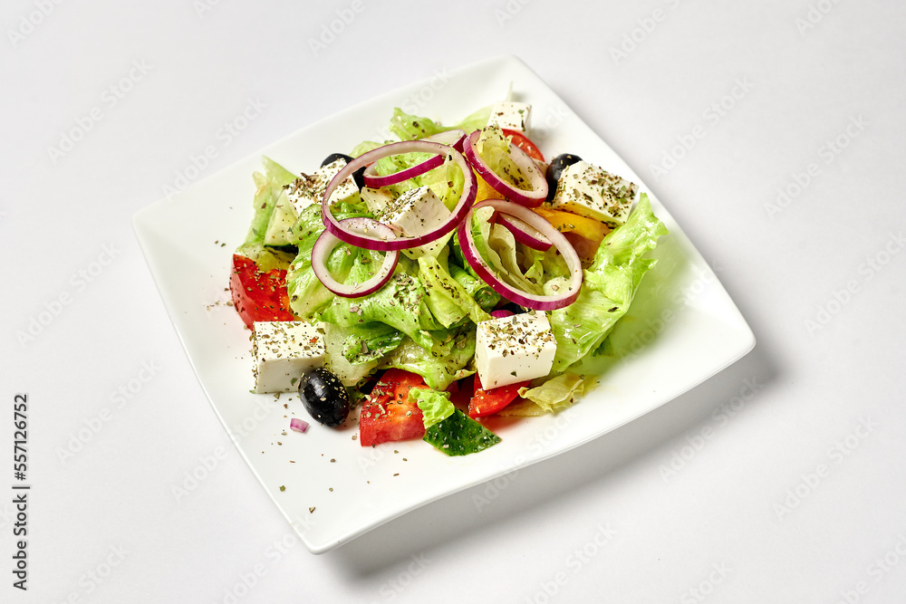 greek salad in a white plate on a white background greek salad in a white plate on a white background