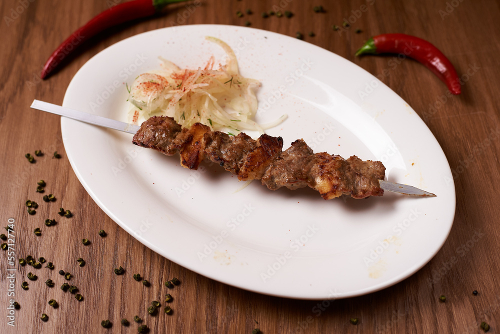 skewers of lamb on a white plate skewers of lamb on a white plate