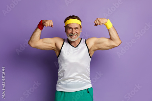 Fototapeta Naklejka Na Ścianę i Meble -  Super Power. Man Showing Biceps. Strong Bearded Man Posing Isolated On Violet Background Studio. Showing Biceps, Muscles 
