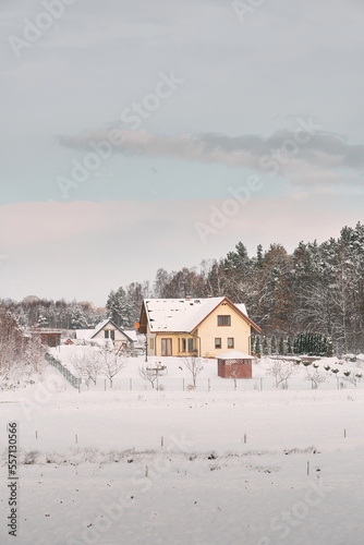 Cozy home exterior in winter. Wooden house in a nature area covered with freshly fallen snow. © AlexGo