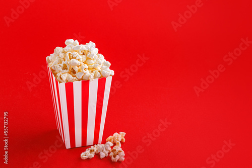 Glass with popcorn on a red background