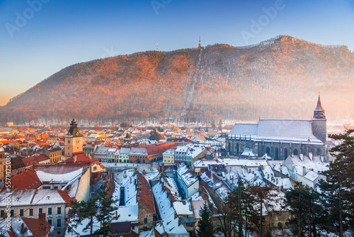 Brasov, Romania. Black Church and Carpathian Mountain, winter snowy downtown, sunset time. photo