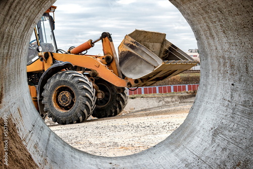 The excavator loader works with a bucket for transporting sand at a construction site. Professional construction equipment for earthworks.