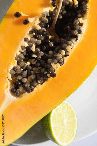 Ripe and freshly cut papaya with its seeds and white background. Fresh and tropical fruit