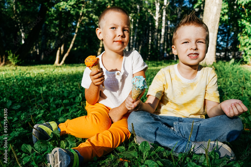 Kid boys eating ice cream on grass. Kid boys eating ice cream on grass.