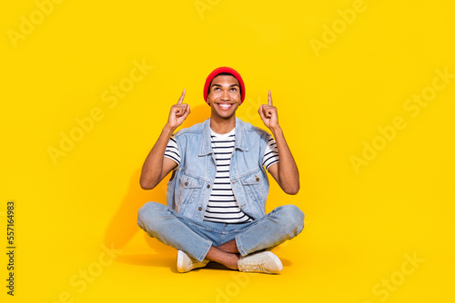 Full length photo of dreamy cheerful man wear jeans outfit showing two fingers up empty space isolated yellow color background © deagreez